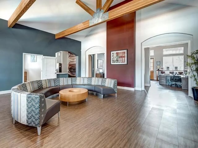 Curved sectional sofa with round wood table living room at Bishops Square in San Marcos Student Accommodation