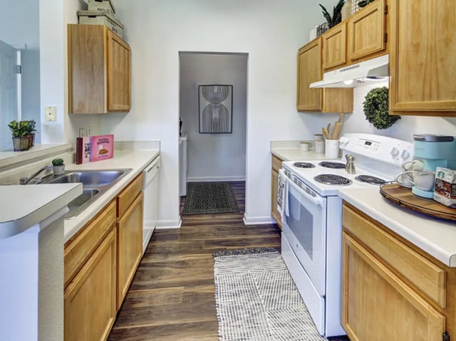 Wood cabinets white appliances sink and stove kitchen at Bishops Square in San Marcos Student Accommodation