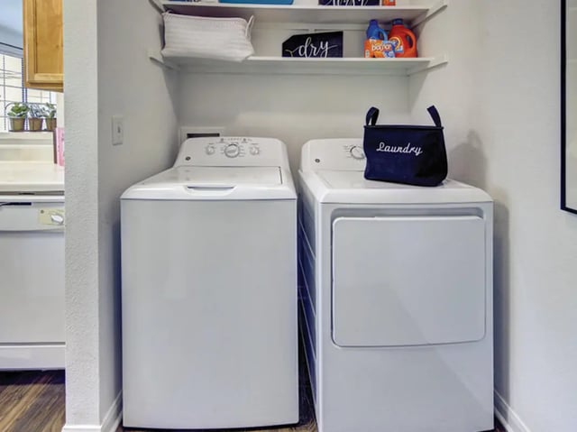 Washer dryer laundry basket cleaning supplies laundry area at Bishops Square in San Marcos Student Accommodation