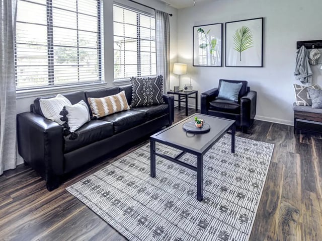 Black sofa armchair rug and coffee table living room at Bishops Square in San Marcos Student Accommodation