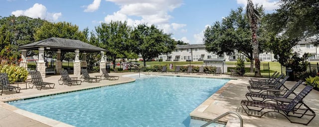 Poolside lounge chairs covered patio area exterior at Bishops Square in San Marcos Student Accommodation
