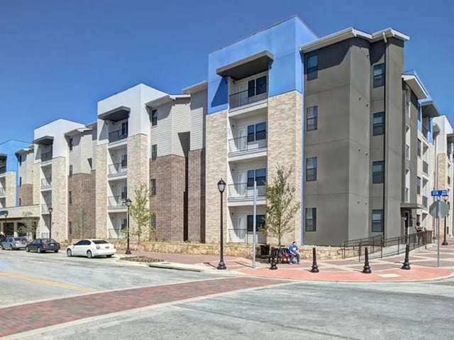 Modern apartment buildings with balconies cars street exterior at Campus Edge on UTA Boulevard in Arlington Student Accommodation