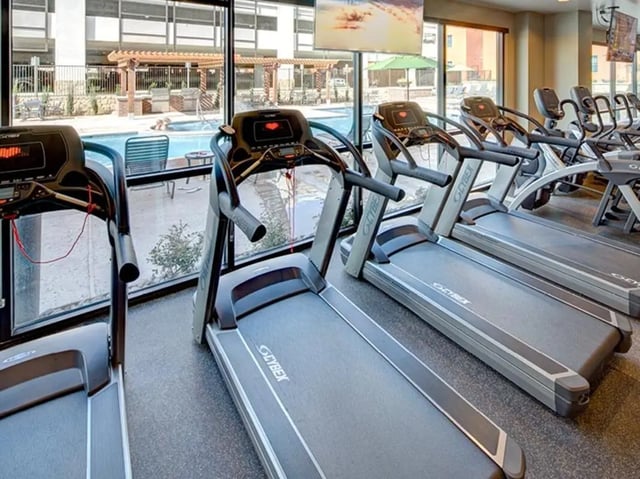 Treadmills and pool visible through window Gym at Campus Edge on UTA Boulevard in Arlington Student Accommodation