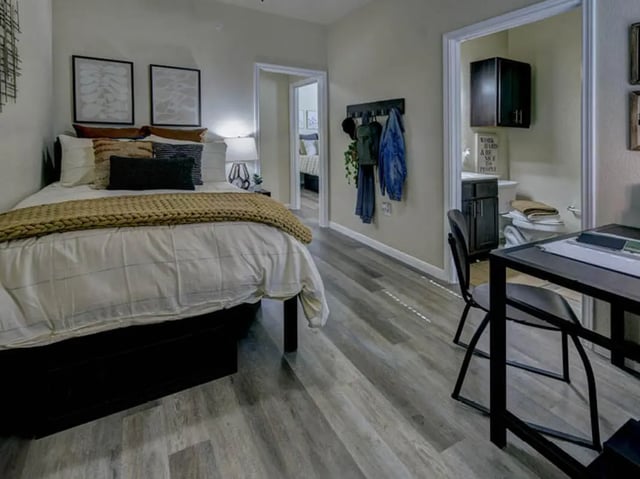 Bed table and bathroom student accommodation bedroom at Campus Edge on UTA Boulevard in Arlington Student Accommodation