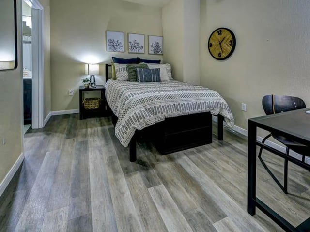Bed nightstand artwork clock table chair bedroom at Campus Edge on UTA Boulevard in Arlington Student Accommodation