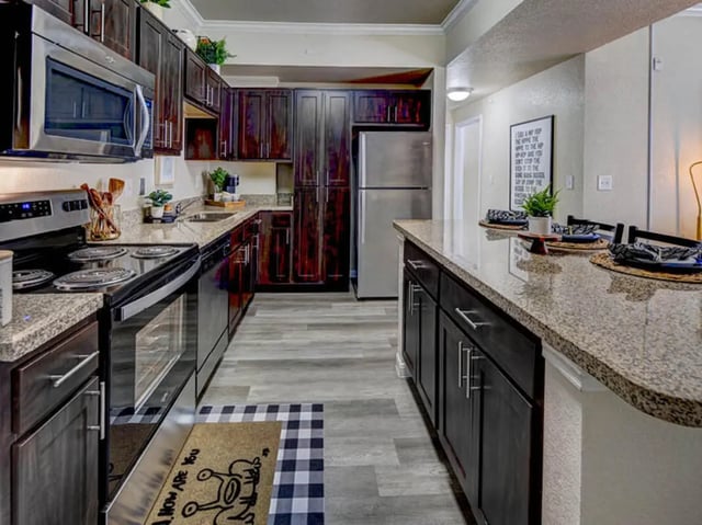 Modern kitchen with dark cabinets and granite island kitchen at Campus Edge on UTA Boulevard in Arlington Student Accommodation