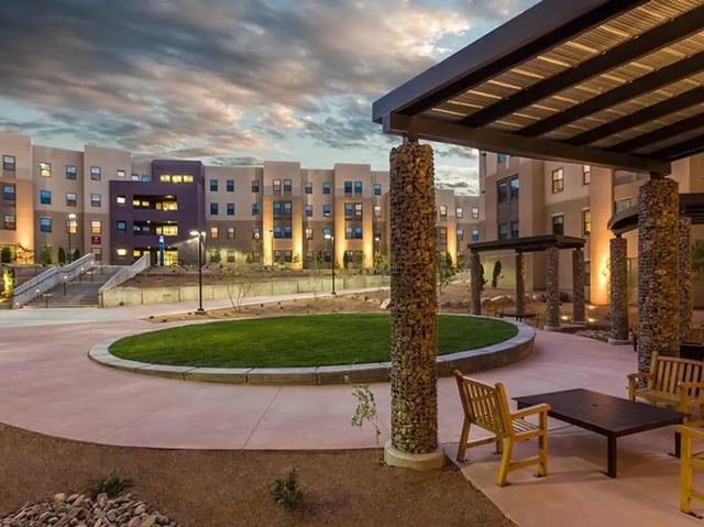 Campus buildings with outdoor seating and green space exterior at Casas del Rio in Albuquerque Student Accommodation