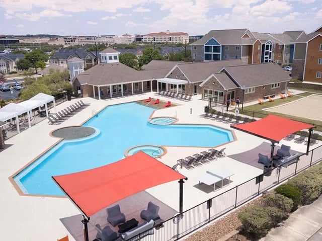 Large blue pool with lounge chairs and cabanas exterior at Campus Edge on UTSA Boulevard in San Antonio Student Accommodation