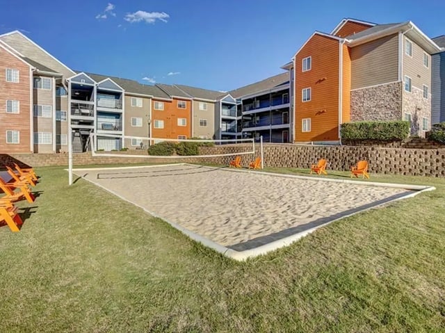 Sand volleyball court with orange chairs exterior at Campus Edge on UTSA Boulevard in San Antonio Student Accommodation