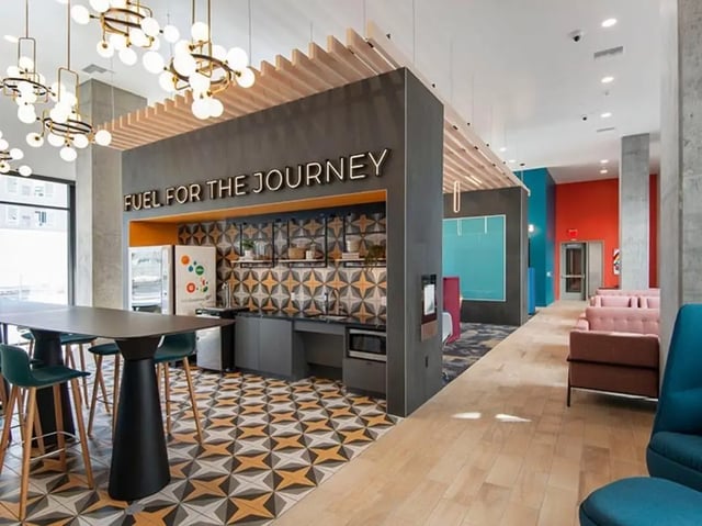 Modern communal kitchen with seating and lounge area at Currie Hall in Los Angeles Student Accommodation