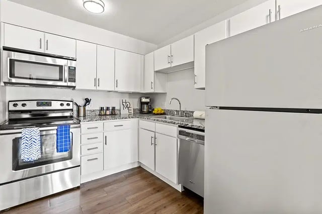 Stainless steel appliances white cabinets granite countertops kitchen at The Lodge