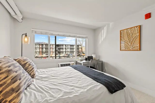 Bed pillows desk lamp air conditioner bedroom at The Lodge