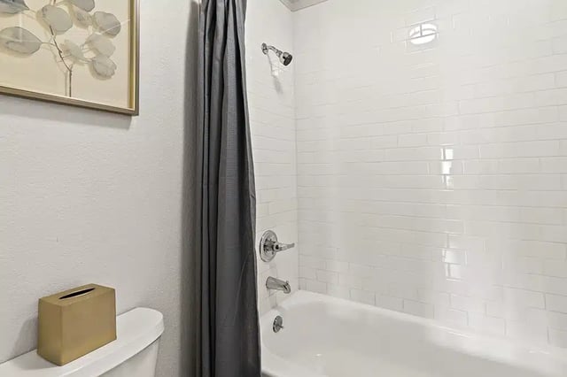 Toilet tissue box artwork shower and bathtub bathroom at The Lodge