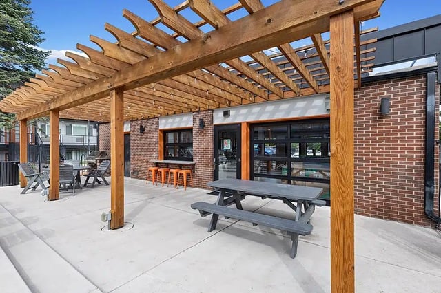 Pergola picnic table chairs bar exterior at The Lodge
