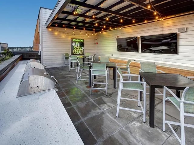 Grills tables chairs neon sign televisions common area at 959 Franklin in Eugene Student Accommodation