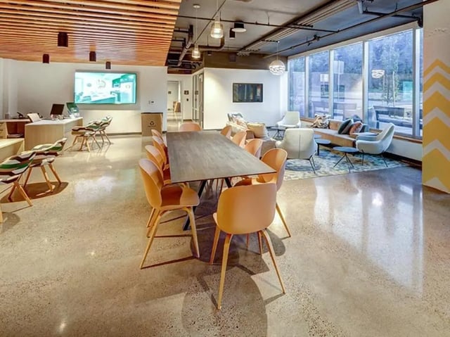 Dining area with long table and orange chairs lounge area living room at 959 Franklin in Eugene Student Accommodation