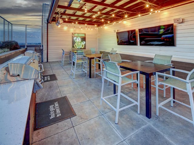 Grills tables chairs neon sign TVs exterior living room at 959 Franklin in Eugene Student Accommodation