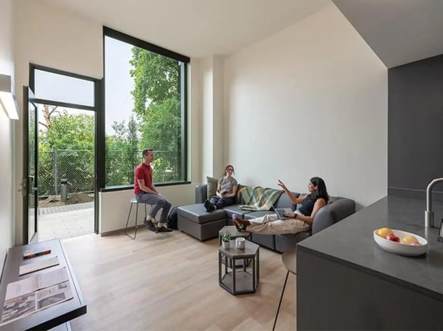 Sofa with people and large window living room at Graduate Junction in Cambridge Student Accommodation