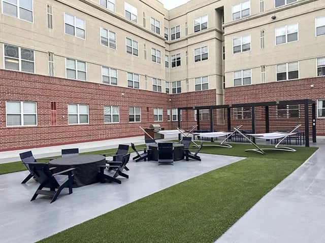 Hammocks tables chairs building exterior at GrandMarc Seven Corners in Minneapolis Student Accommodation