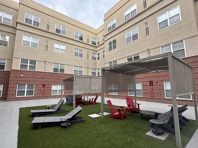 Chairs and lounge beds on grass exterior at GrandMarc Seven Corners in Minneapolis Student Accommodation