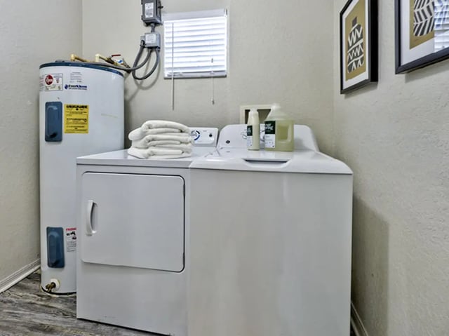 Washer dryer stacked towels and water heater laundry room at Mercury 3100 in Orlando Student Accommodation