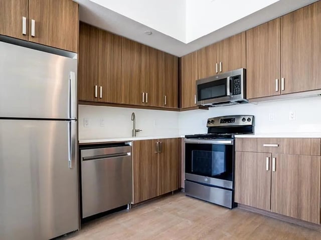 Modern kitchen with stainless steel appliances and wooden cabinets kitchen at North District in Riverside Student Accommodation