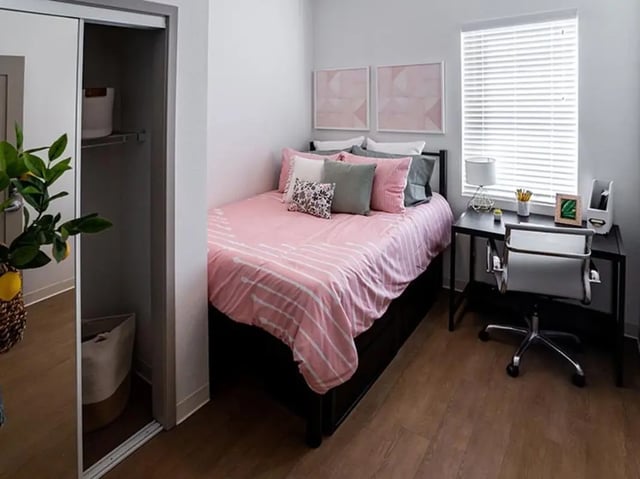 Pink striped duvet pillows desk chair bedroom at North District in Riverside Student Accommodation