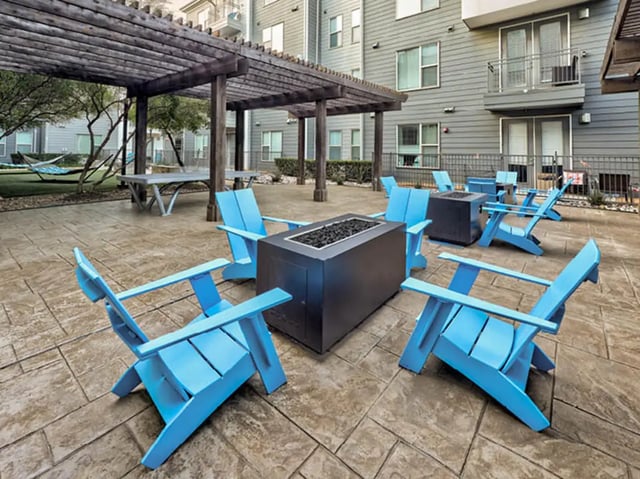Blue chairs surround fire pits patio exterior at The Arlie in Arlington Student Accommodation