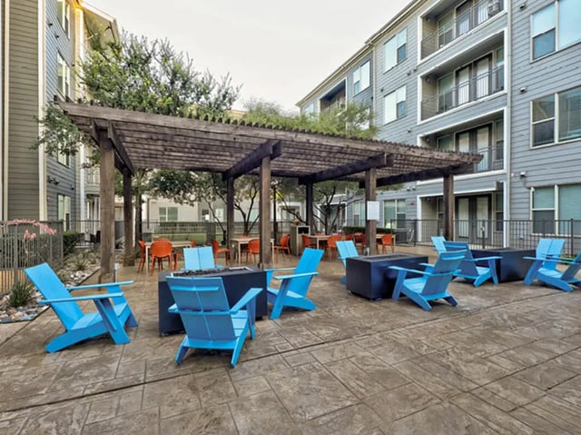 Blue chairs fire pits under pergola outdoor seating area at The Arlie in Arlington Student Accommodation