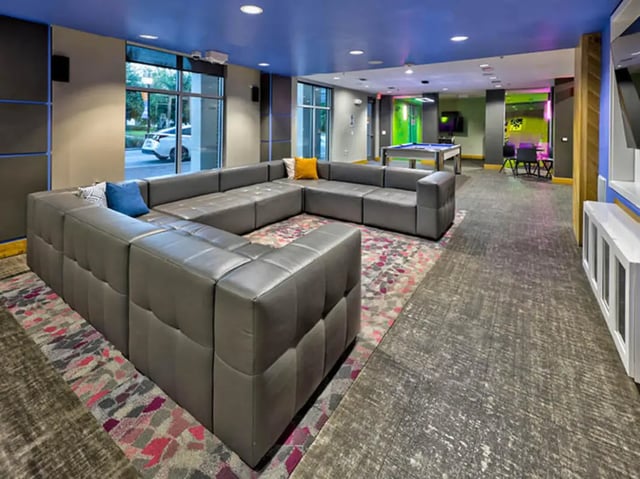 Gray sectional sofa with colorful rug living area at The Arlie in Arlington Student Accommodation