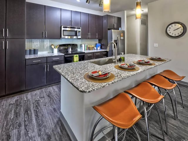 Dark cabinets granite island bar stools kitchen at The Arlie in Arlington Student Accommodation