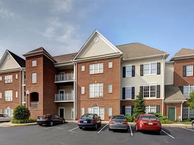 Apartment building with balconies and parked cars exterior at Newtown Crossing in Lexington Student Accommodation