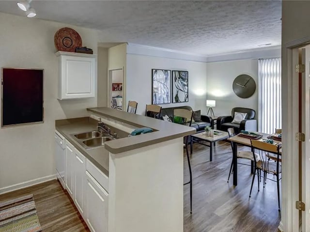 Kitchen island bar with seating and living room dining area living room at Newtown Crossing in Lexington Student Accommodation