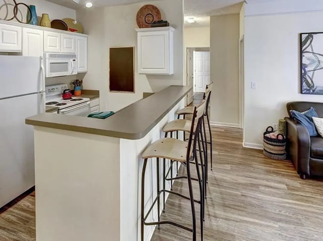Kitchen counter with stools and appliances kitchen at Newtown Crossing in Lexington Student Accommodation