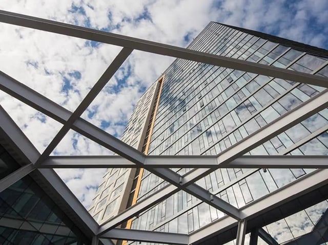 Modern glass building exterior with sky and clouds. at The Summit at University City in Philadelphia Student Accommodation