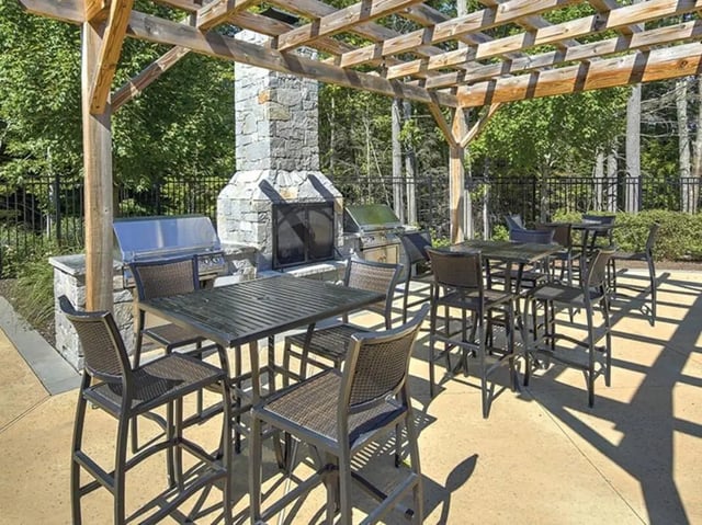 Outdoor dining area with grills and fireplace outdoor living area at The Cottages of Durham in Durham Student Accommodation