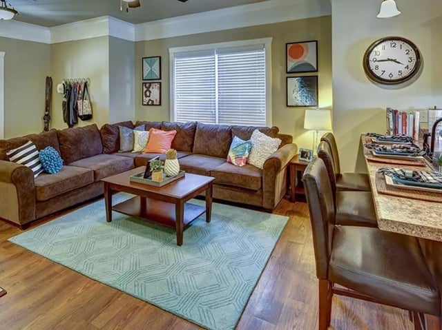Brown sectional sofa coffee table light rug living room at The Cottages of Durham in Durham Student Accommodation