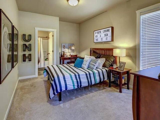 Bed with striped bedding study desk framed art bedroom at The Cottages of Durham in Durham Student Accommodation