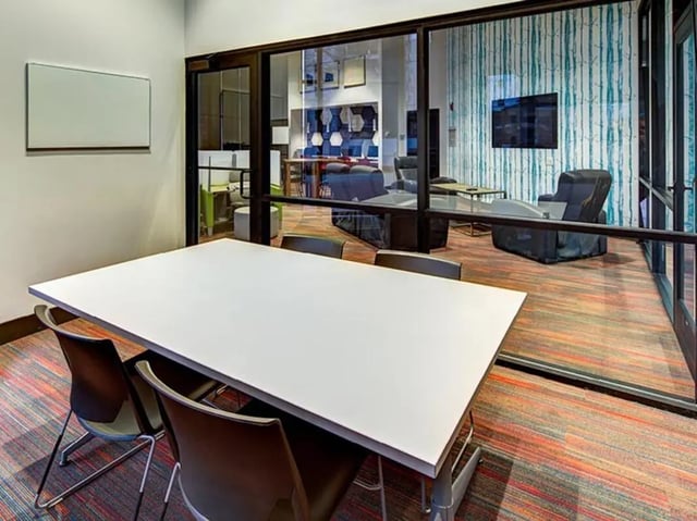White table chairs large windows common area at The Tower at Third in Champaign Student Accommodation