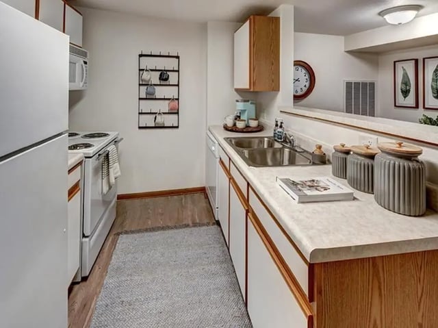 White refrigerator stove sink counter coffee maker kitchen at The Tower at Third in Champaign Student Accommodation