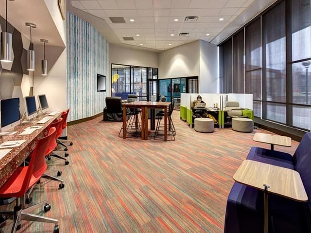 Computers tables chairs and seating common area at The Tower at Third in Champaign Student Accommodation