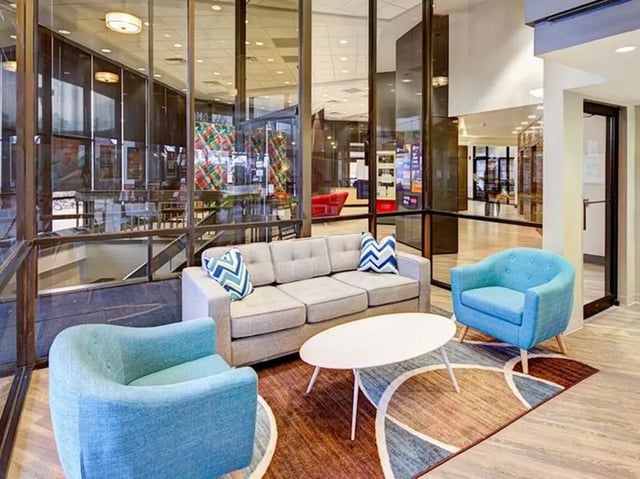 Sofa chairs oval table with rug living room at The Tower at Third in Champaign Student Accommodation