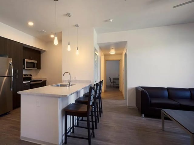 Kitchen island bar stools and sofa living room at Plaza Verde in Irvine Student Accommodation