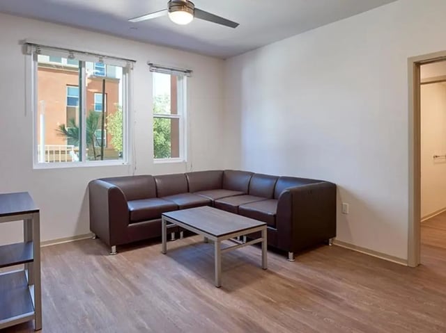 Brown sectional sofa coffee table living room at Plaza Verde in Irvine Student Accommodation