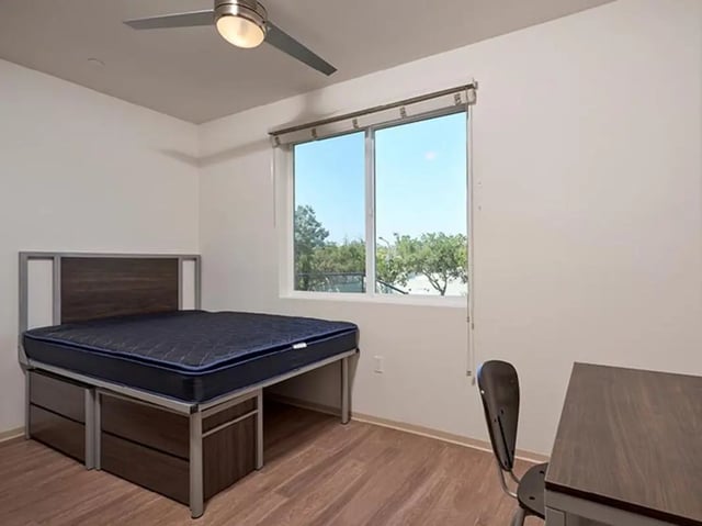 Bed desk chair and ceiling fan bedroom at Plaza Verde in Irvine Student Accommodation