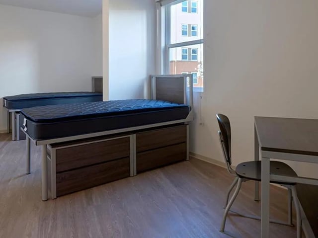 Two beds with drawers desks and chair Bedroom at Plaza Verde in Irvine Student Accommodation