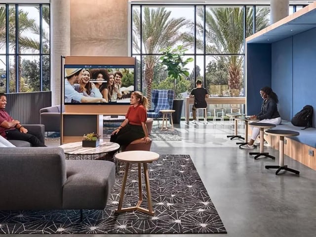 People in lounge with TV and study area living room at Plaza Verde in Irvine Student Accommodation