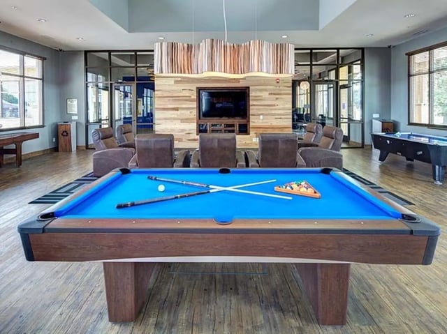 Pool table with cues and balls playing area at The Townhomes at Newtown Crossing in Lexington Student Accommodation