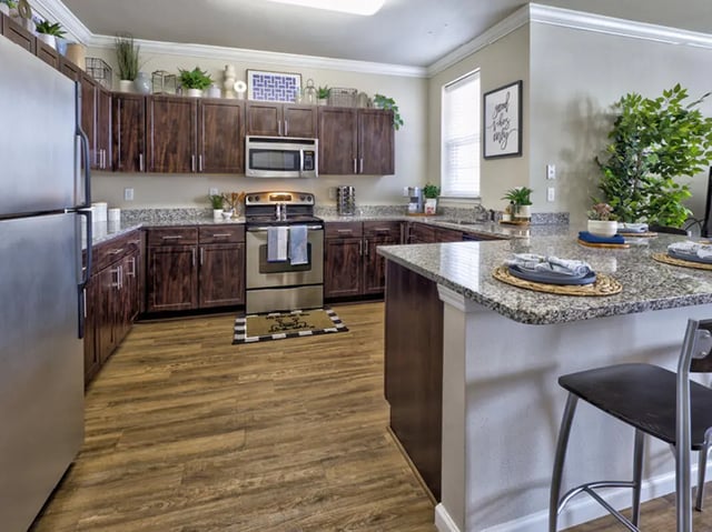 Stainless steel refrigerator dark cabinets granite counters kitchen at The Townhomes at Newtown Crossing in Lexington Student Accommodation