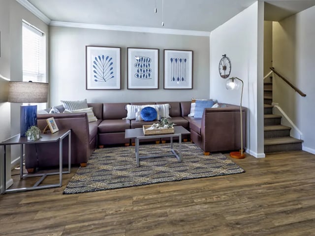 Leather sectional rug framed art stairs living room at The Townhomes at Newtown Crossing in Lexington Student Accommodation